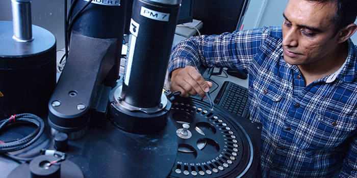 Researcher Mayank Jain places a sample—in the form of sand grains—for analysis in an apparatus which can measure the luminescence of the material. It will help determine the age of the material. Photo: Mikal Schlosser