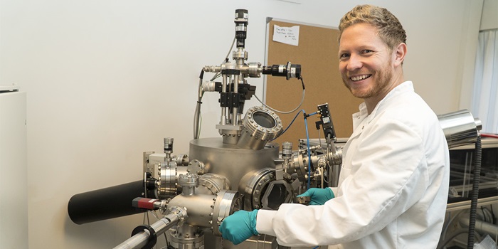 Researcher Dennis Christensen in front of the Pulsed Laser Deposition facility at DTU Energy