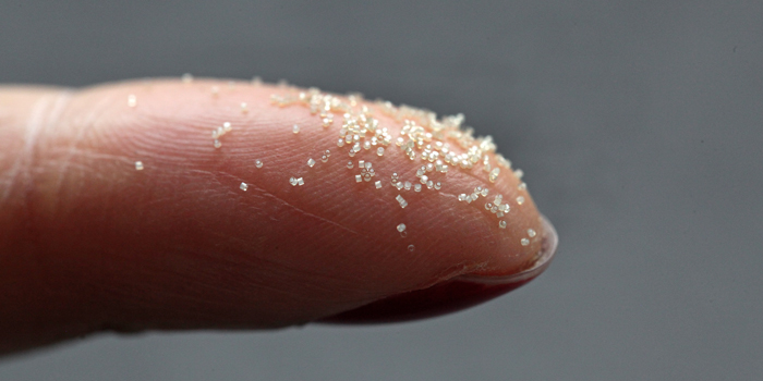 Mikrokapsler med medicin er hver især mindre end et sandkorn. Der kan således sidde hundredevis af mikrokapsler på spidsen af en pegefinger. Foto: Jesper Scheel