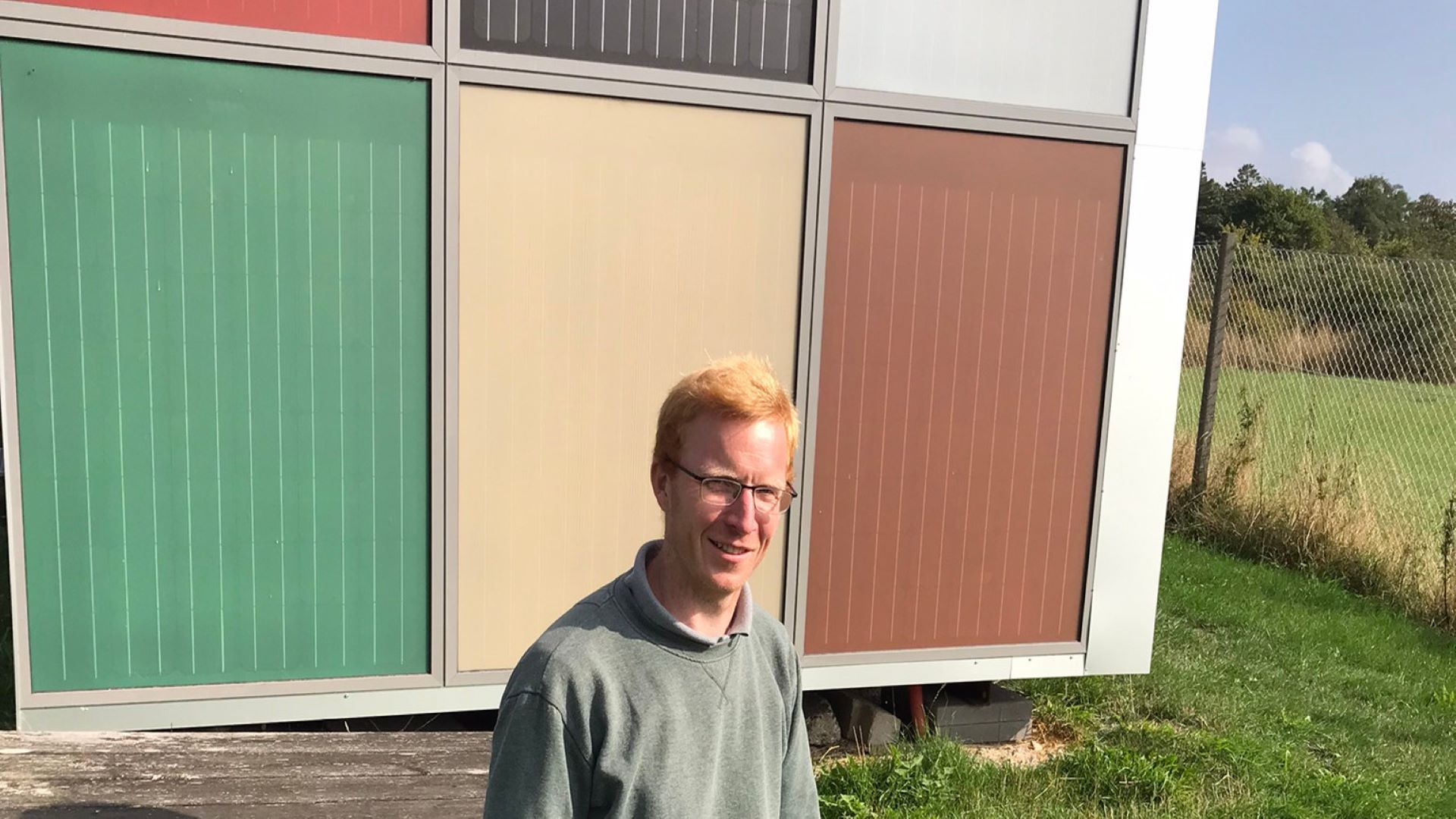 Sune Thorsteinsson foran bygningsintegrerede solcellepaneler