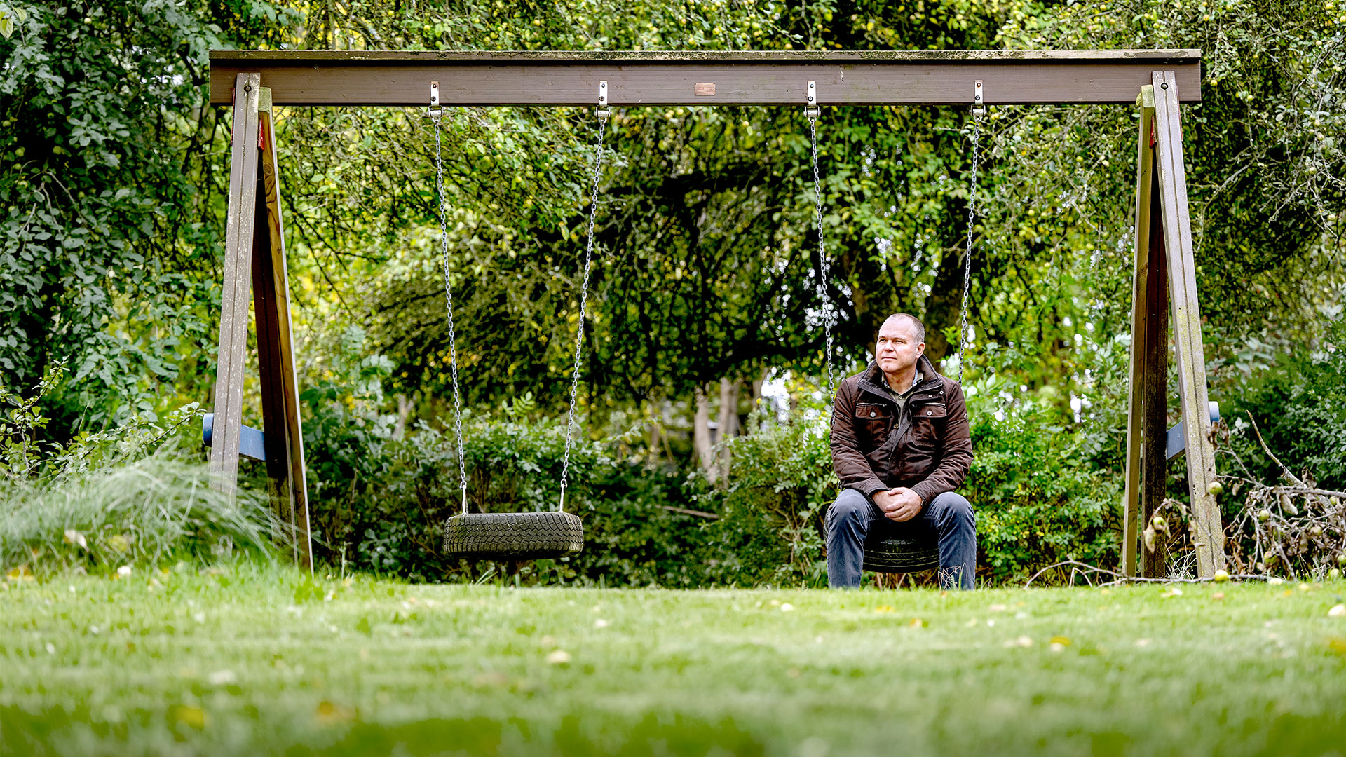 Mand sidder på den ene af to gynger i et gyngestativ. Foto: Bax Lindhardt ©Bax Lindhardt Mand sidder på den ene af to gynger i et gyngestativ. Foto: Bax Lindhardt