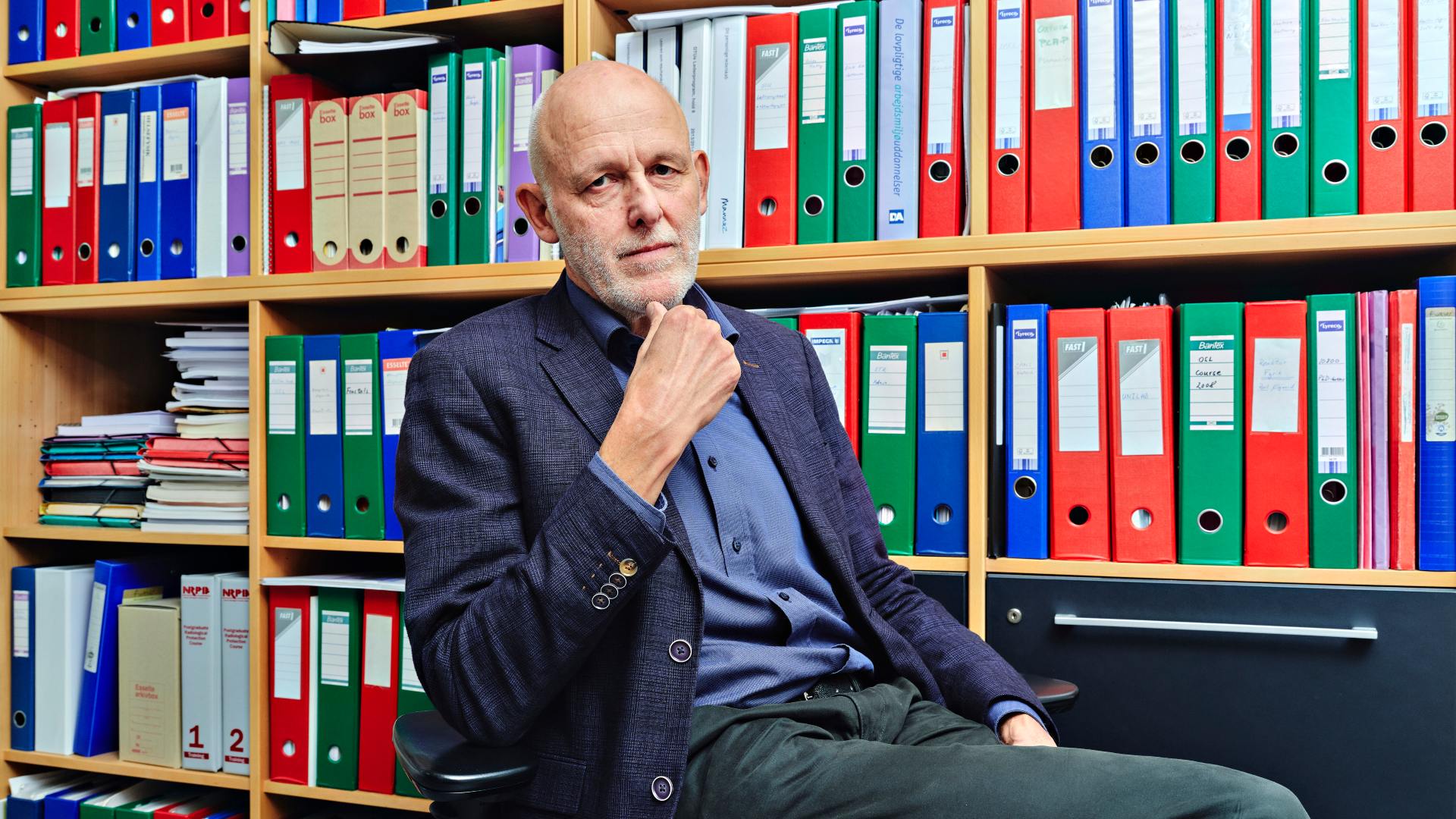 Centerleder Bent Lauritzen omgivet af mapper på sit kontor.