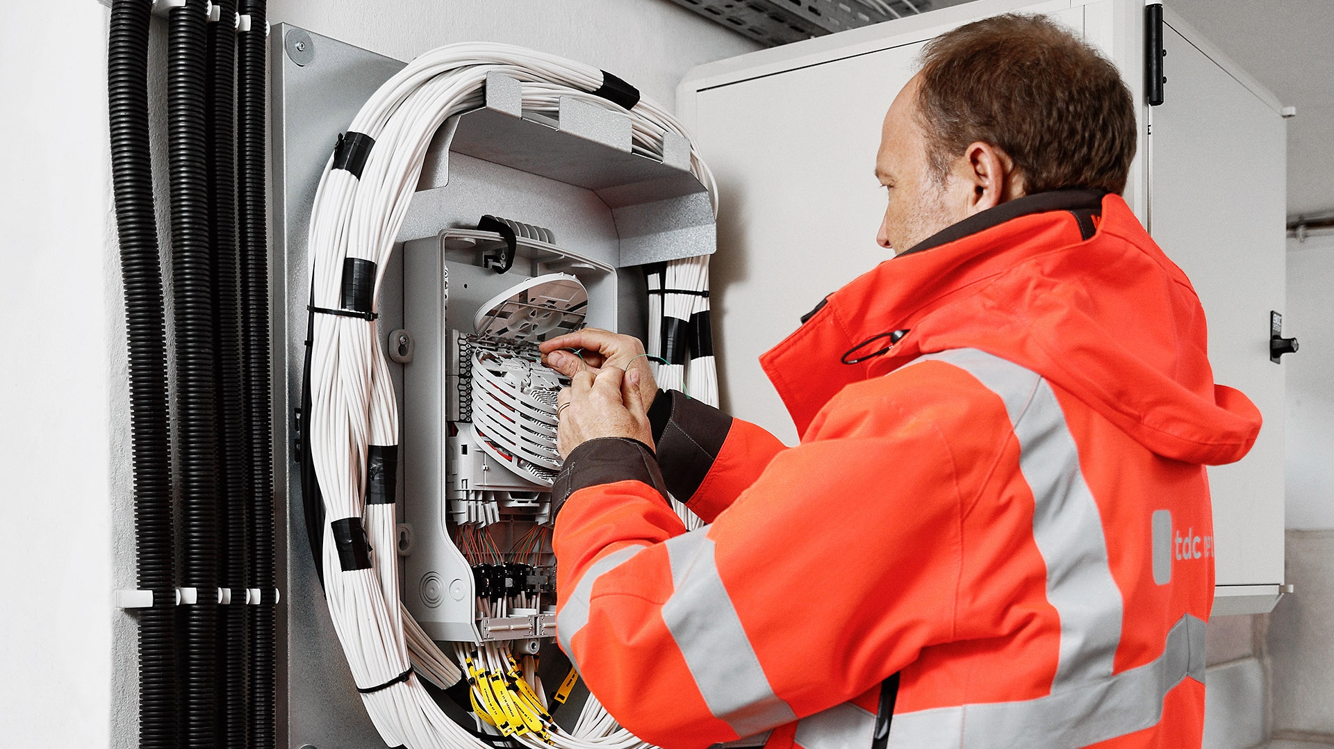 Mand reparerer en fibernetfordeler