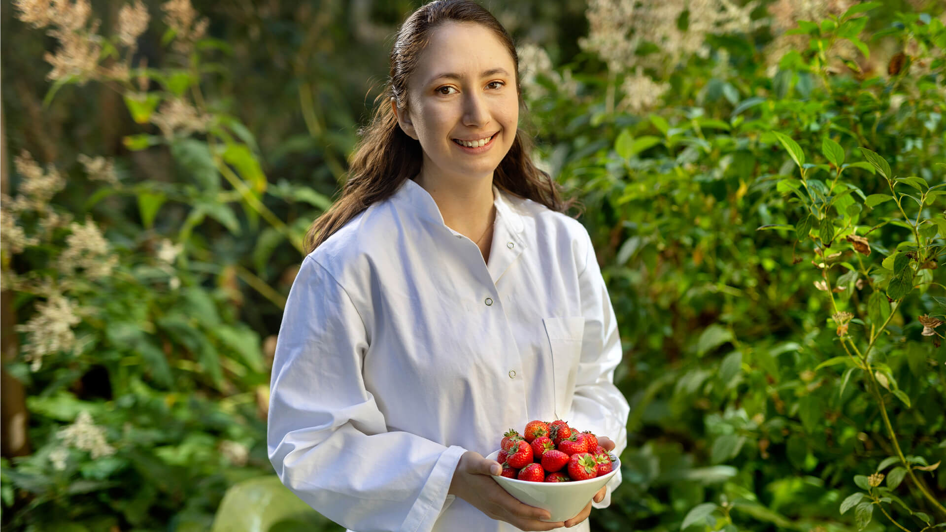 Masters student Maria Riquelme holding a bowl of strawberries. Photo: Mikal Schlosser