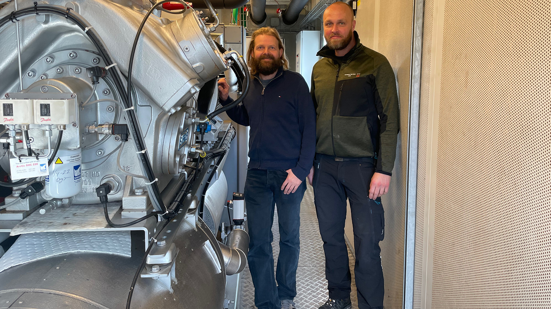 With a heat pump connected to DTU's data center, Esben Højrup and Bjarke Nonbøl from DTU Campus Service utilize waste heat from cooling servers. The heat pump supplies heat to the district heating network on Risø Campus.