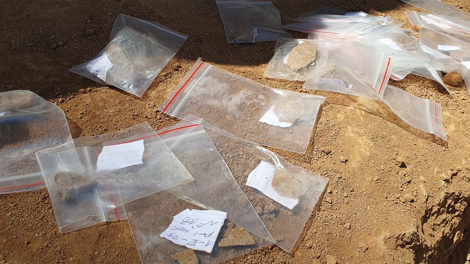 Ancient stone tools put in plastic bags and laid out on the ground. Photo: Miriam Meister