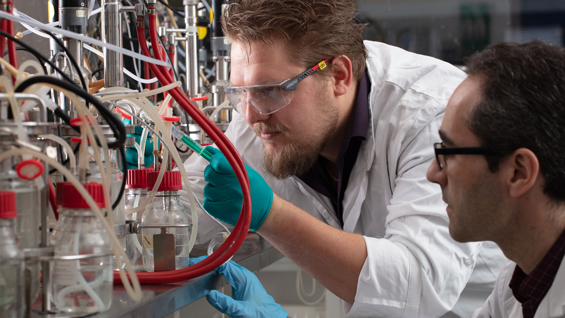 Two men in a laboratory working with fermentors. Photo: Mikal Schlosser