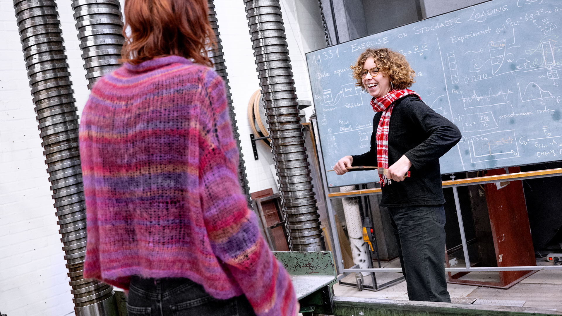 Woman standing in front of a blackboard filled with calculations. Photo: Bax LIndhardt