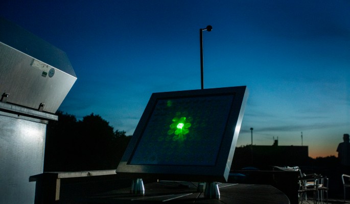 Grønt laserlys sendes ind mod reflektorerne på Mirror Stage, hvorfra det så viderereflekteres i retning af månen. (Foto: DTU Space/Mikal Schlosser)