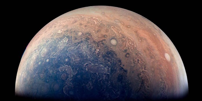 Indflyvning mod Jupiter med Juno, sammensat af data fra missionen. De ovale mønstre – eller cirkler - er storme på overfladen nær planetens poler.  Illustration: NASA/JPL